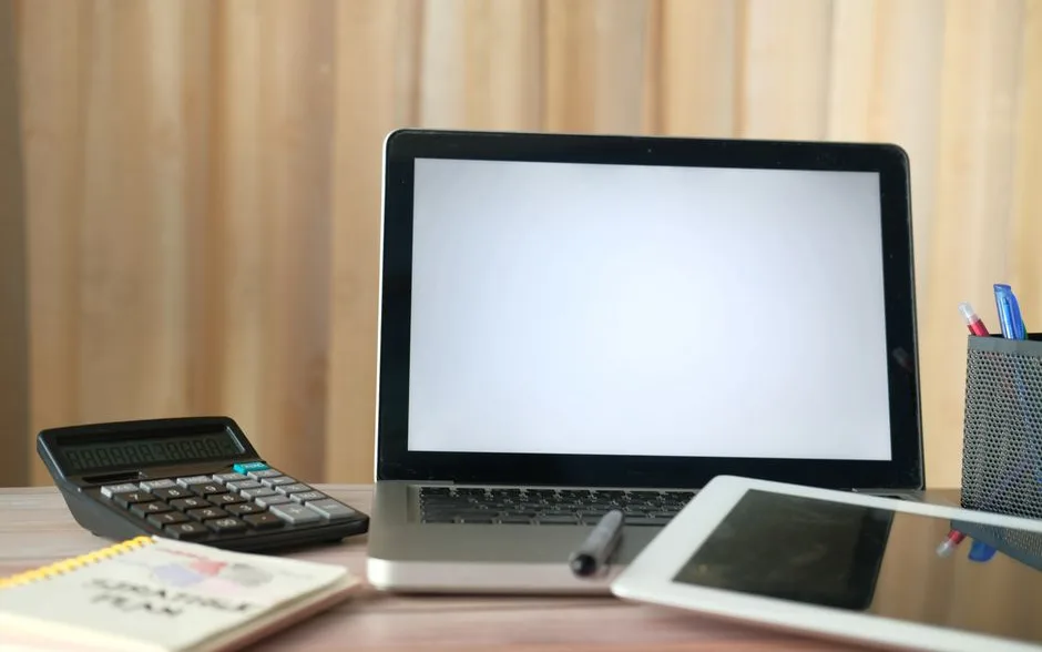 Bureau avec ordinateur portable, calculatrice et tablette prêts pour la gestion